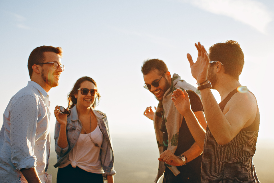 Friends laughing together outdoors at sunset